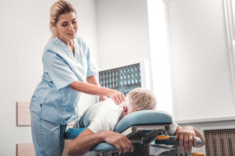 A chiropractor and a massage therapist working with clients in a clinical treatment room.